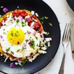 These healthier Huevos Rancheros nix the deep fried chips in favor of a single baked tortilla topped with a rich red chili sauce and a single sunny egg.